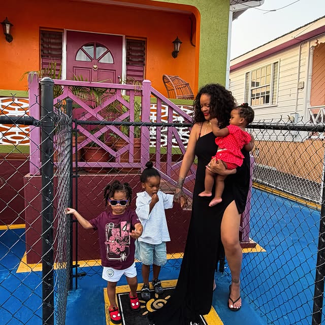 Rihanna stands with her children outside her childhood neighborhood on Rihanna Drive in Barbados.