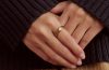 Oura Ring 5 worn alongside gold jewelry, showing its slim design and jewelry-like appearance.