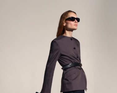 A woman wears a polished modern work outfit featuring tailored clothing, contemporary accessories, and comfortable footwear.