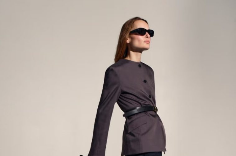 A woman wears a polished modern work outfit featuring tailored clothing, contemporary accessories, and comfortable footwear.