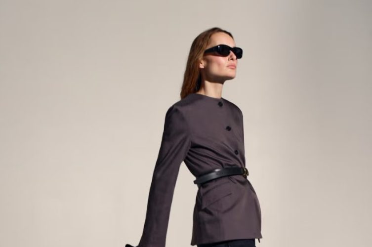 A woman wears a polished modern work outfit featuring tailored clothing, contemporary accessories, and comfortable footwear.