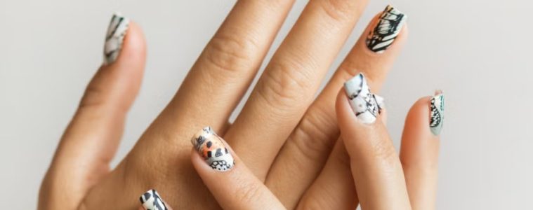 A minimalist animal-print manicure featuring subtle leopard, zebra, crocodile, and cow-inspired nail designs.