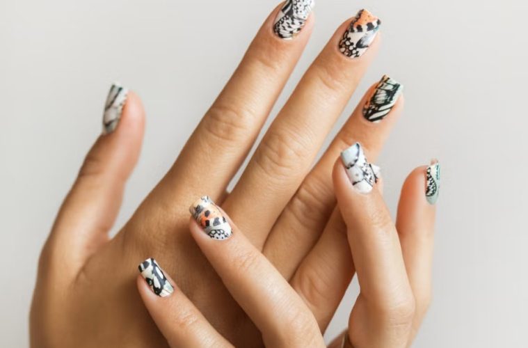 A minimalist animal-print manicure featuring subtle leopard, zebra, crocodile, and cow-inspired nail designs.