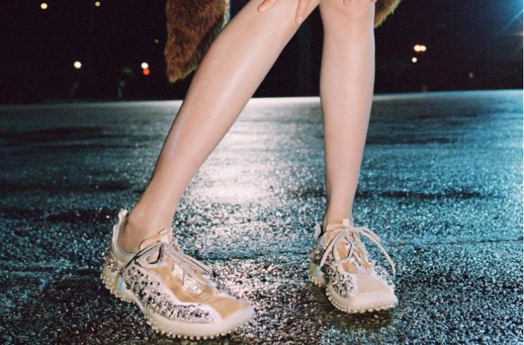 A fashion-forward look featuring archival-inspired shoes alongside modern clothing in a contemporary street-style setting.