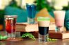 A selection of colorful modern beverages featuring sparkling fruit drinks, botanical sodas, tea, and alcohol-free spritzes.