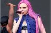 A woman with glossy pink hair in a soft rose shade showcasing the 2026 pink hair color trend.