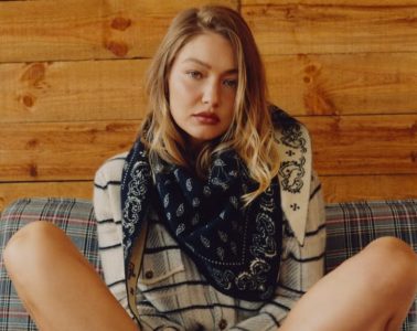 A woman wearing a paisley bandana-print outfit with denim and accessories styled for the transition from summer to fall.