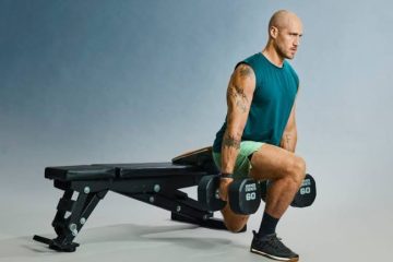 A person performs a Bulgarian split squat with one foot elevated on a bench during a lower-body workout.