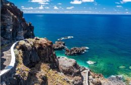 Scenic El Hierro coastline with volcanic rock formations, Atlantic Ocean views, and lush island landscape.