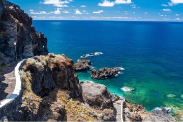 Scenic El Hierro coastline with volcanic rock formations, Atlantic Ocean views, and lush island landscape.