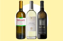 A chilled bottle and glass of Italian Vermentino white wine served with Mediterranean seafood and herbs.