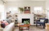 A warm and inviting living room featuring layered lighting, comfortable textiles, greenery and thoughtful decorative accents.
