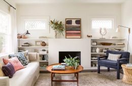 A warm and inviting living room featuring layered lighting, comfortable textiles, greenery and thoughtful decorative accents.