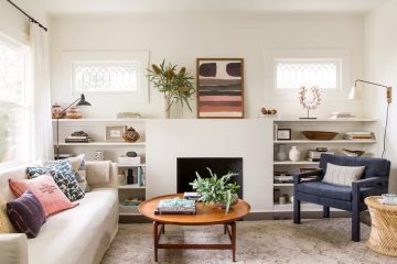 A warm and inviting living room featuring layered lighting, comfortable textiles, greenery and thoughtful decorative accents.