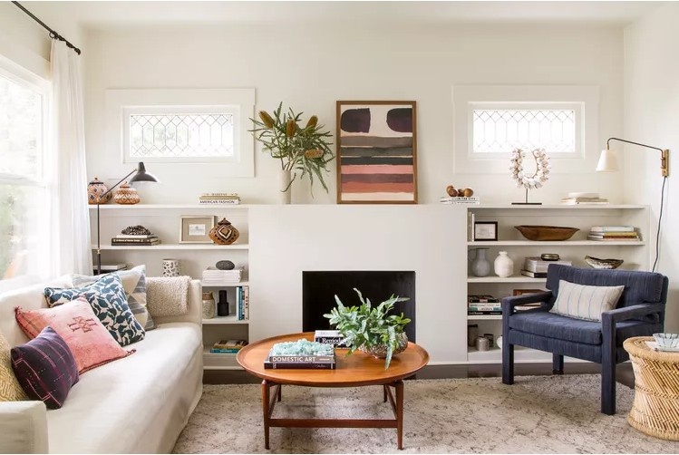 A warm and inviting living room featuring layered lighting, comfortable textiles, greenery and thoughtful decorative accents.