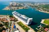 Cruise ship arriving at a scenic Mexican port with tropical coastline and turquoise Caribbean waters.