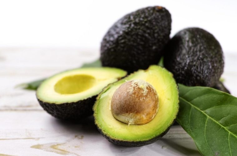 Fresh avocado halves and sliced avocado served as part of a colorful heart-healthy meal.