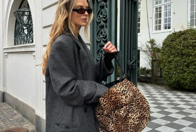 A selection of leopard and cheetah-print handbags styled with neutral fall clothing and everyday accessories.