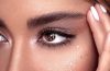 Woman gently removing waterproof mascara with a cotton pad as part of a nighttime beauty routine.