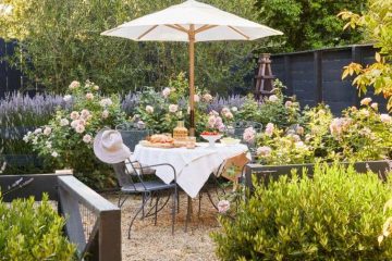 Charming British-inspired outdoor garden with layered plants, comfortable seating, natural materials, and colorful accents.