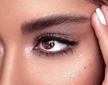 Woman gently removing waterproof mascara with a cotton pad as part of a nighttime beauty routine.