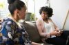 Mental health professional having a supportive conversation with a diverse client in a welcoming healthcare setting.