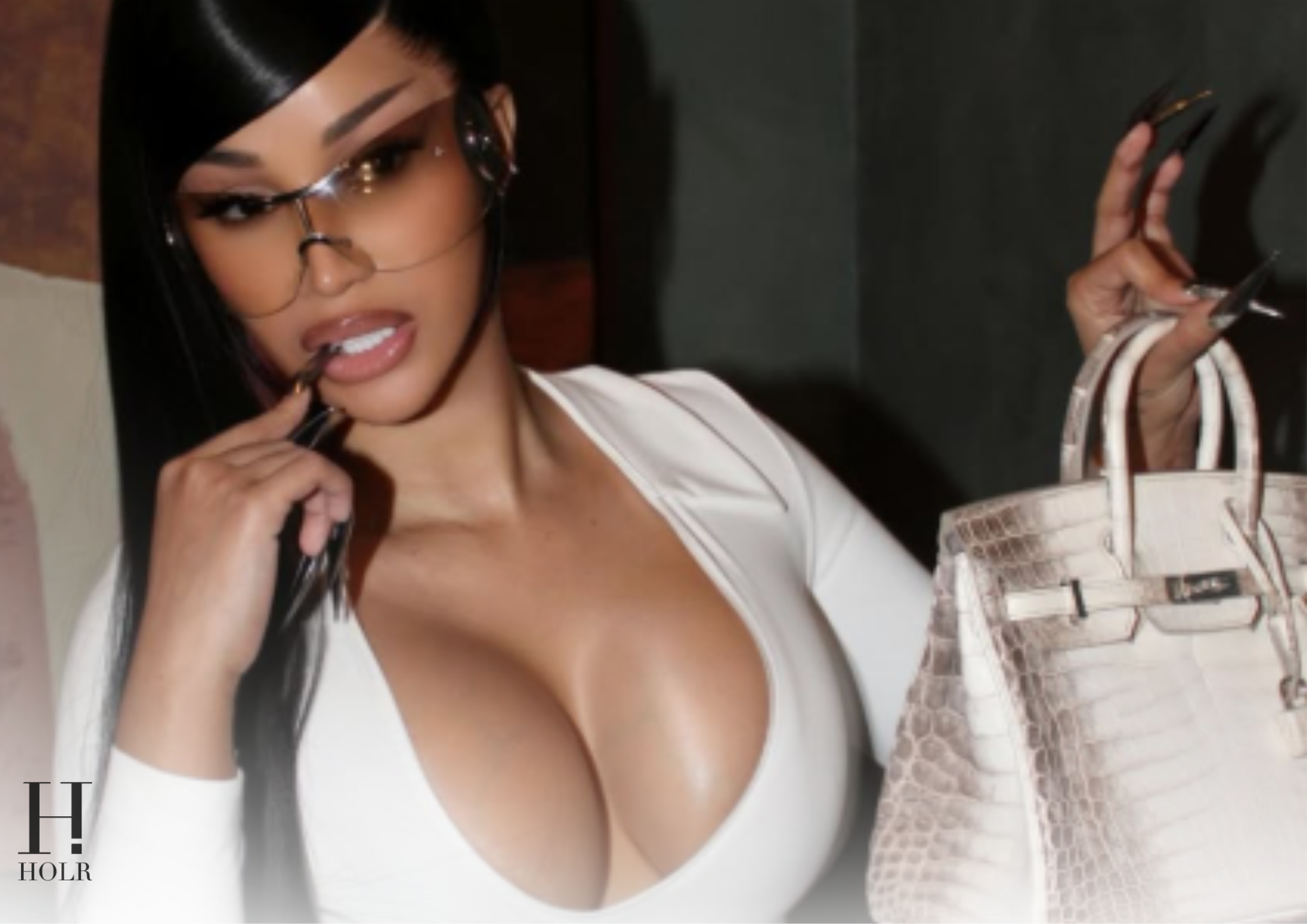 ardi B poses in a white outfit with a luxe grey Hermès Birkin bag