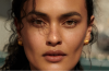 Five sheer bronzer products are displayed with makeup brushes to showcase lightweight formulas for creating a natural, dewy sun-kissed complexion.