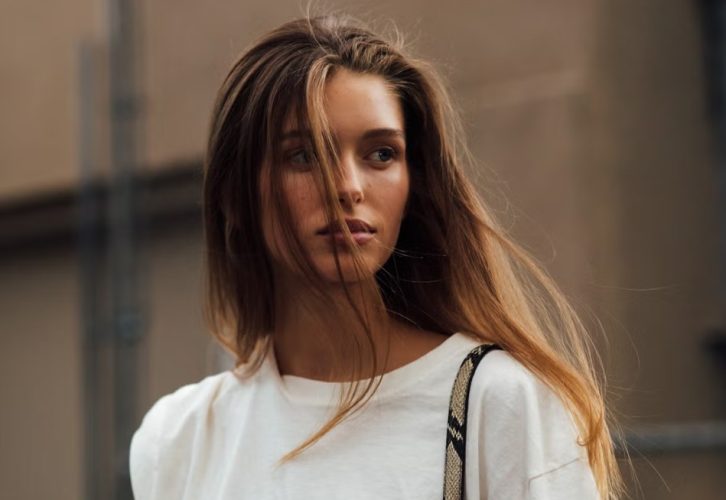 A selection of lightweight conditioners for fine hair arranged beside soft, voluminous strands styled to look fuller and healthier.