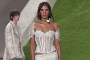 A Cult Gaia runway model wears a loose romantic ponytail and softly flushed berry-toned makeup with a dreamy, afterglow-inspired finish.