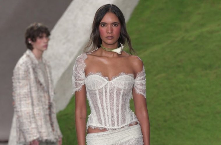 A Cult Gaia runway model wears a loose romantic ponytail and softly flushed berry-toned makeup with a dreamy, afterglow-inspired finish.