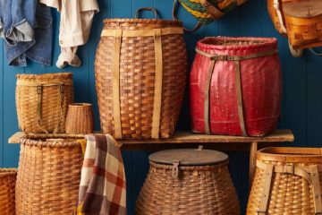 A collection of vintage woven baskets and rustic cabin antiques arranged together to showcase cozy Adirondack-inspired decorating style.