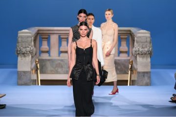 A Tory Burch Spring 2027 runway model wears a polished yet playful look combining bold accessories, tailored pieces, and unexpected styling.